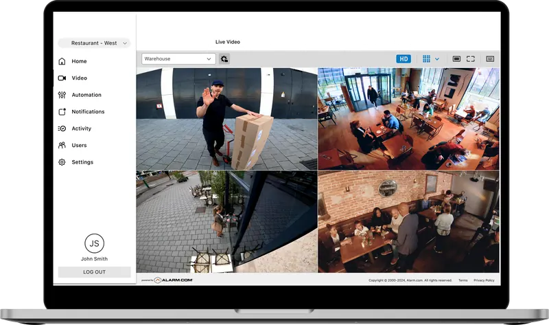 Alarm.com customer website on a laptop showing a four-camera live video grid