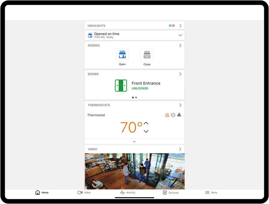 Alarm.com business dashboard on a tablet with scenes, doors, thermostat and video