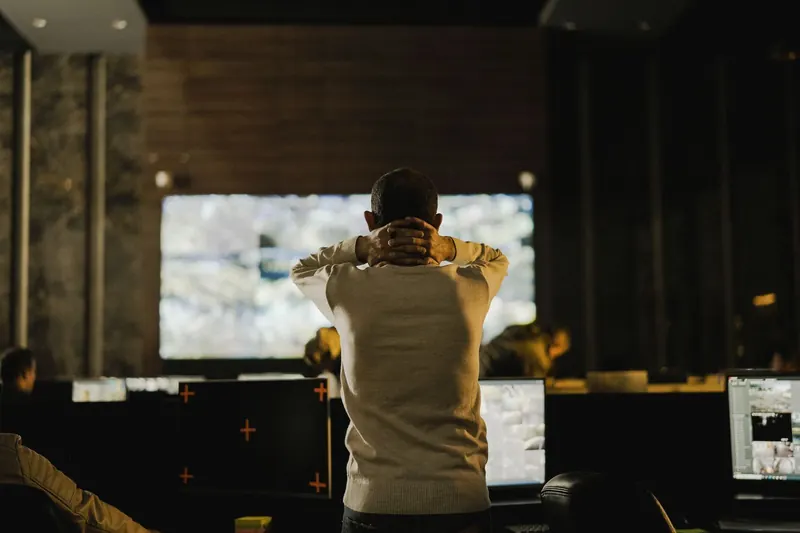 Operator facing monitors in a dimly lit monitoring room